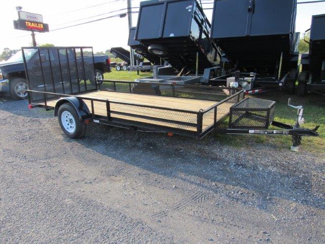 a trailer with a wooden deck is parked on the side of the road next to a dump trailers