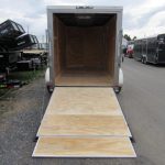 a trailer with the door open is parked on the side of the road .