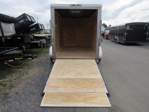 a trailer with the door open is parked on the side of the road .