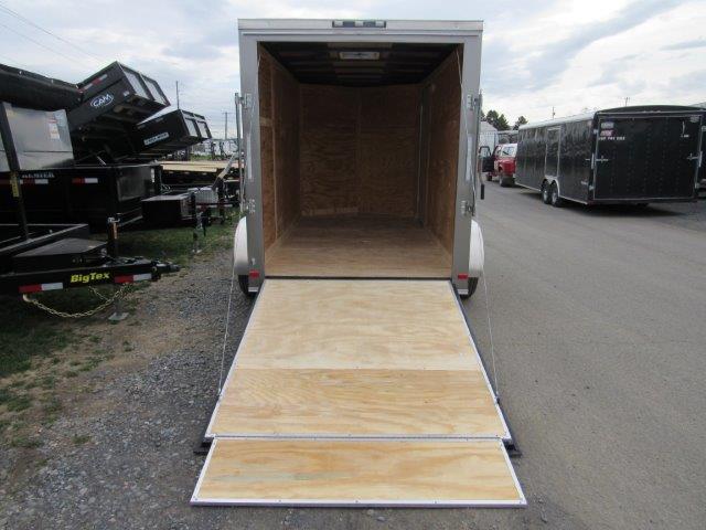 a trailer with the door open is parked on the side of the road .