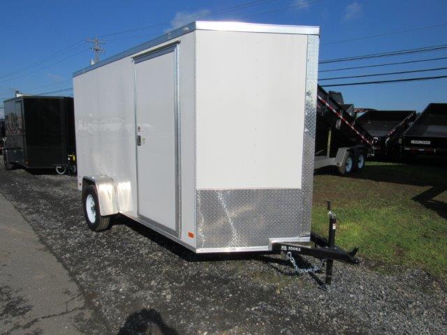 a white trailer is parked on the side of the road .