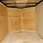 an empty room with wooden walls and a door .