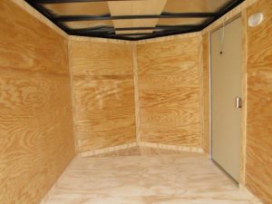 an empty room with wooden walls and a door .