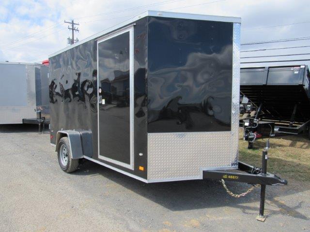 a black and silver trailer is parked in a parking lot .