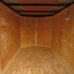 the inside of a trailer with wooden floor and walls