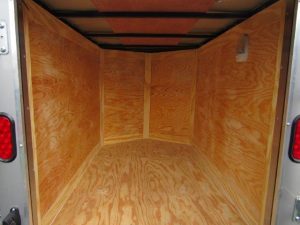 the inside of a trailer with wooden floor and walls