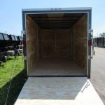 the inside of an empty trailer is shown with the door open .
