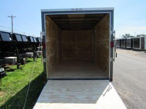 the inside of an empty trailer is shown with the door open .