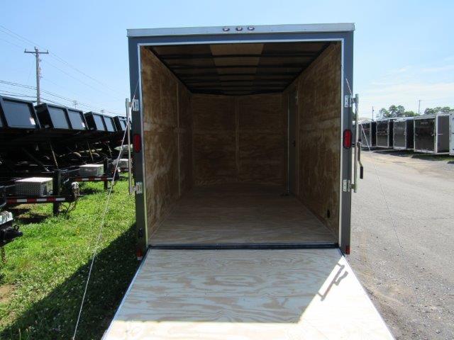 the inside of an empty trailer is shown with the door open .