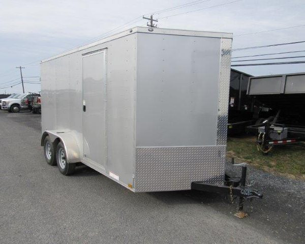 a white trailer is parked on the side of the road .