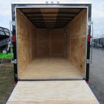 the inside of a Diamond Cargo trailer with the door open and a wooden floor