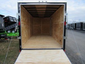 the inside of a Diamond Cargo trailer with the door open and a wooden floor