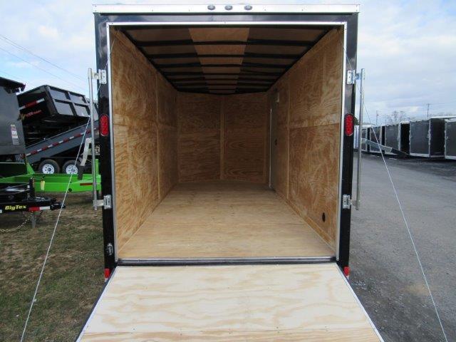 the inside of a Diamond Cargo trailer with the door open and a wooden floor