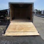 a diamond cargo trailer with the door open is parked on the side of the road .