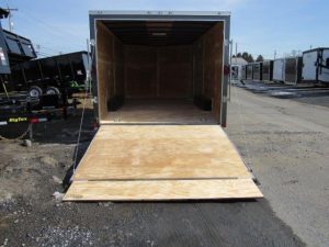 a diamond cargo trailer with the door open is parked on the side of the road .