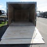 a trailer with the door open is parked on the side of the road .