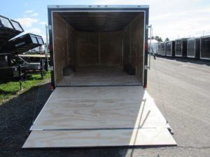 a trailer with the door open is parked on the side of the road .