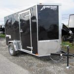 a black trailer parked on the side of the road