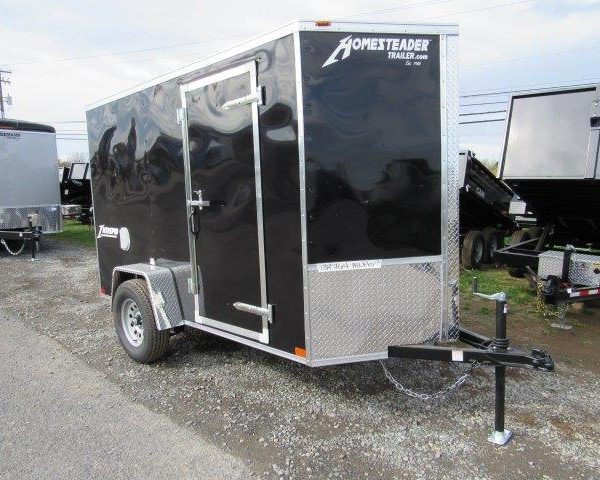 a black trailer parked on the side of the road