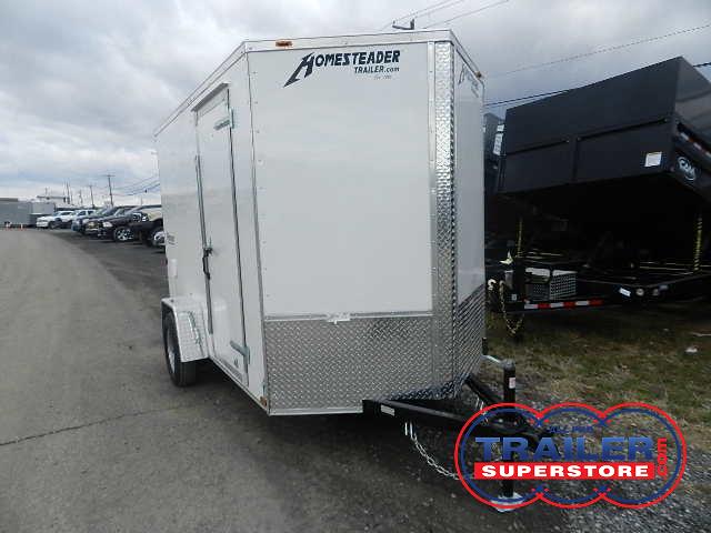 a white trailer is parked on the side of the road in a parking lot .