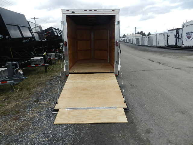 a Homesteader trailer with a wooden ramp parked on the side of the road