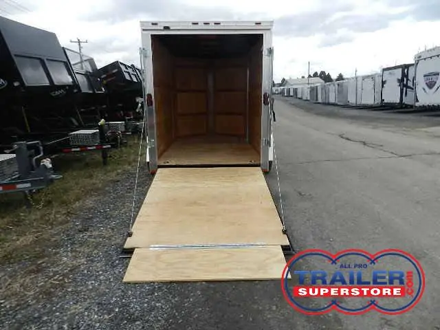 a Homesteader trailer with a wooden ramp parked on the side of the road