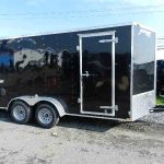 a black trailer parked on the side of the road