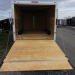the back of a homesteader trailer with the door open and a wooden floor .