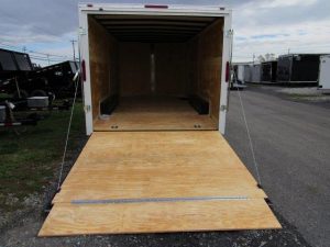 the back of a homesteader trailer with the door open and a wooden floor .