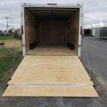 a white trailer with the door open and a wooden ramp