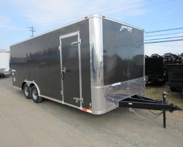 a black and silver trailer is parked on the side of the road .