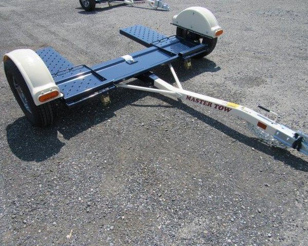 a motorcycle trailer is sitting on top of a gravel road .