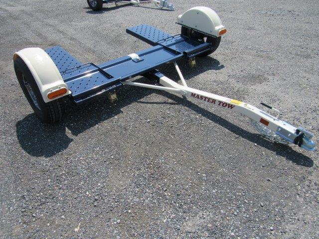 a motorcycle trailer is sitting on top of a gravel road .