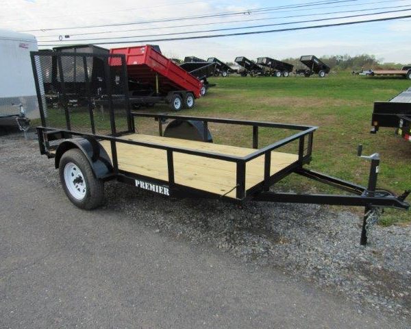 a trailer with a wooden deck is parked on the side of the road .