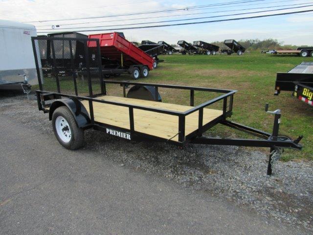 a trailer with a wooden deck is parked on the side of the road .