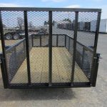 a trailer with a mesh gate is parked in a parking lot