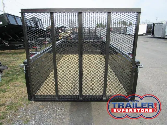 a trailer with a mesh fence on the back is parked in a parking lot .