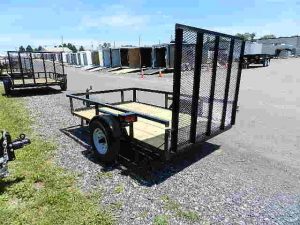 a Premier landscape utility trailer parked on a gravel road