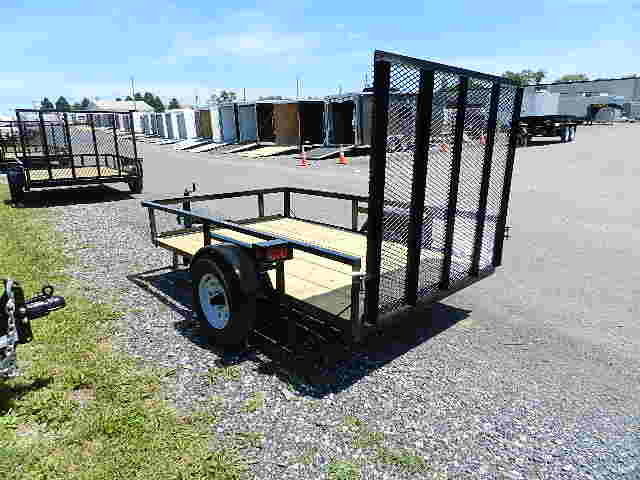 a Premier landscape utility trailer parked on a gravel road