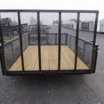 a Premier landscape utility trailer with mesh sides parked in a lot