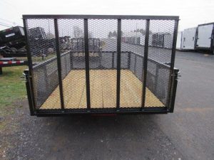 a Premier landscape utility trailer with mesh sides parked in a lot