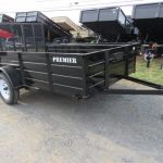 a black trailer is parked on the side of the road .