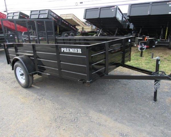 a black trailer is parked on the side of the road .