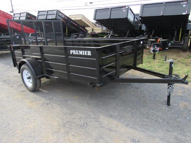 a black trailer is parked on the side of the road .