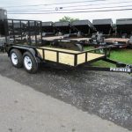 a Premier trailer parked on the side of the road next to a row of dump trailers