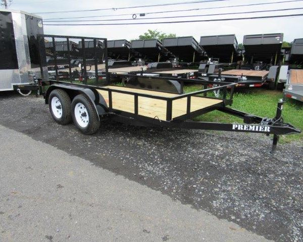 a Premier trailer parked on the side of the road next to a row of dump trailers