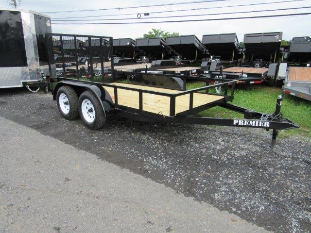 a Premier trailer parked on the side of the road next to a row of dump trailers
