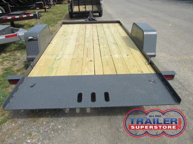 a trailer with a wooden deck is parked on the side of the road .