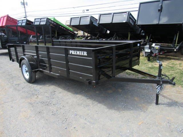 a black trailer parked next to a row of dump trailers