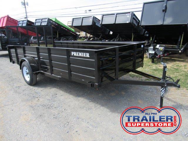 a black trailer parked next to a row of dump trailers